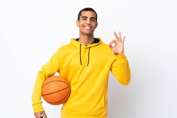 African American man over isolated white background playing basketball and making OK sign - Fotografie, Obrázek