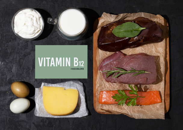 Um conjunto de produtos naturais ricos em vitamina B12 cobalamina. Conceito de alimentação saudável. Assinatura do cartão com a inscrição. Fundo preto. - Foto, Imagem