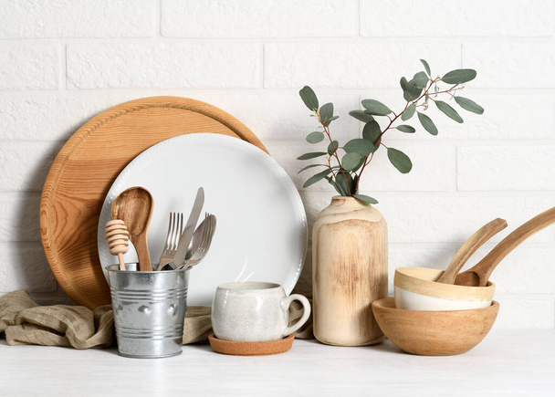 Arrangement of tableware against a white brick wall - Foto, afbeelding