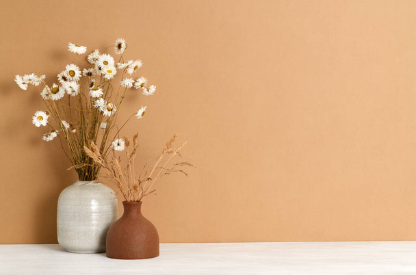 Beaux bouquets de plantes sèches contre un mur brun - Photo, image