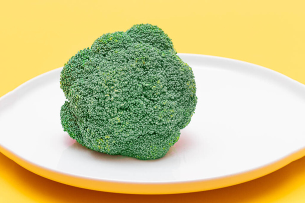 Fresh and Raw Broccoli on White Dish. Uncooked Green Cabbage - Фото, изображение