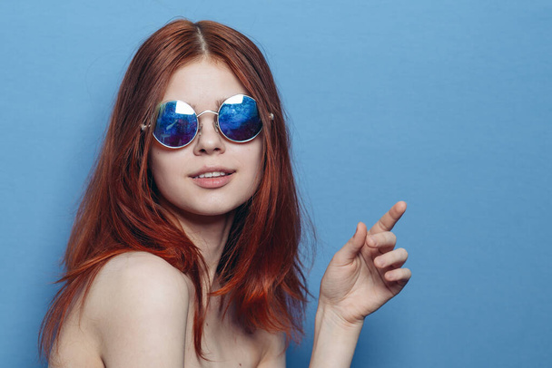 perky red-haired woman in blue glasses bare shoulders posing - Fotó, kép