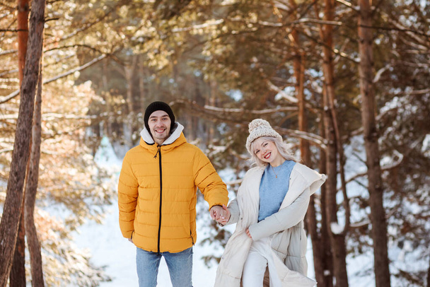 Happy couple spending Christmas vacation outdoors in the countryside in the snowy forest. - Photo, image