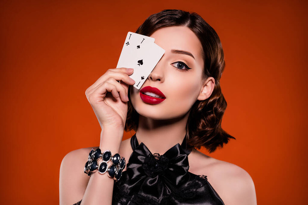 Zdjęcie młodej uroczej uroczej kobiety okładka karty oczne as grać gracz izolowany na ciemnopomarańczowy kolor tła - Zdjęcie, obraz