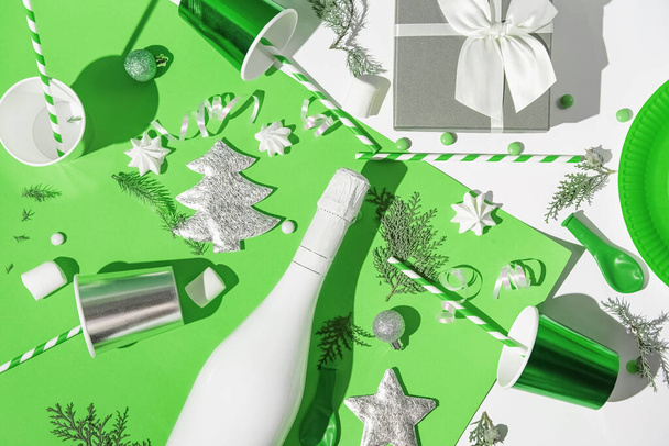 Χριστουγεννιάτικη σύνθεση από χάρτινα ποτήρια με καλαμάκια, κουτί δώρου, λευκό μπουκάλι σαμπάνιας, μαρέγκες και πράσινα μπιχλιμπίδια. Εορταστική και κόμμα έννοια. 2022 νέο έτος φόντο. - Φωτογραφία, εικόνα