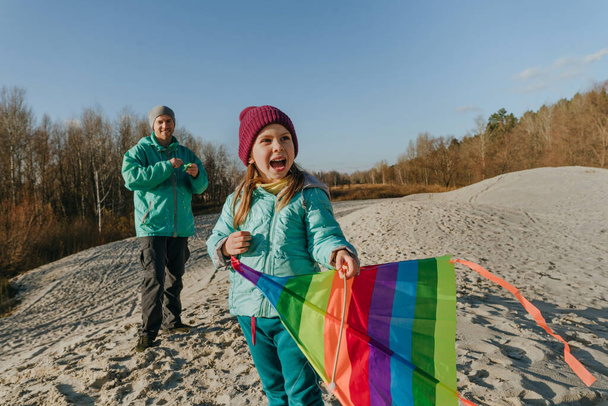 Father with his 5 years old daughter prepairing kite to fly. Happy family activities outdoor. Parenthood concept. - Photo, Image