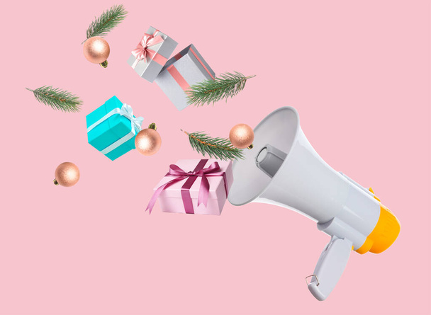 Flying megaphone with Christmas gifts and decorations on pink background - Fotoğraf, Görsel