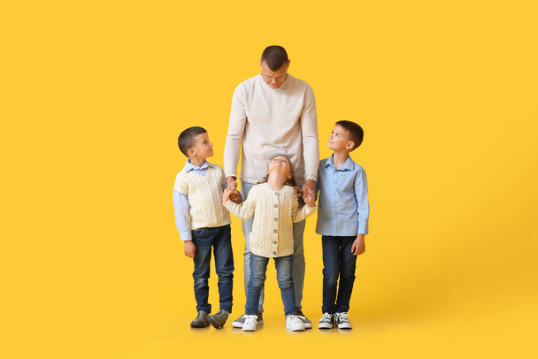 黄色の背景に小さな子供を持つ父親の肖像画 - 写真・画像