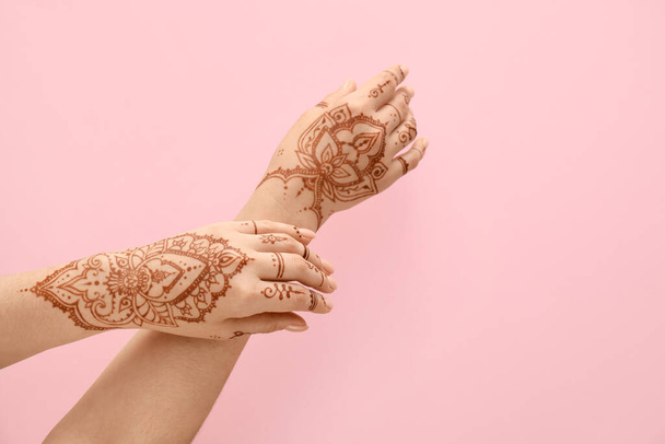 Beautiful female hands with henna tattoo  on pink background - Photo, Image
