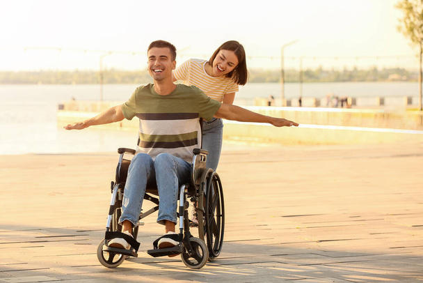 Młody mężczyzna z niepełnosprawnością fizyczną i jego żona na świeżym powietrzu - Zdjęcie, obraz