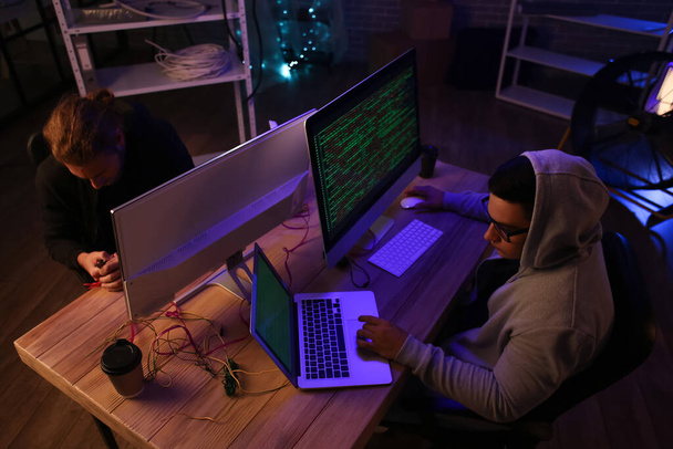 Hackers in donkere kamer met computers - Foto, afbeelding