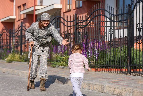 Bebê menina conhecer sua mãe militar ao ar livre - Foto, Imagem