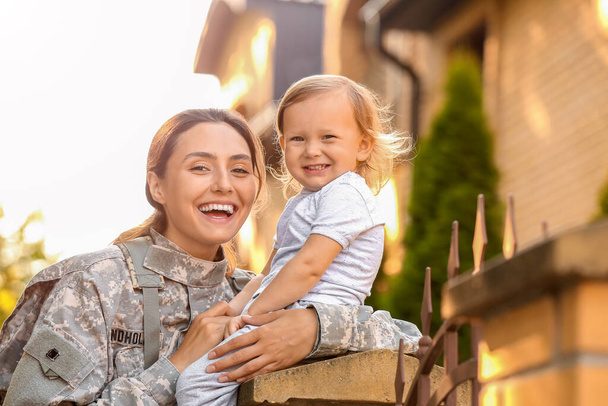 Жінка-солдат зі своєю маленькою донькою на відкритому повітрі
 - Фото, зображення