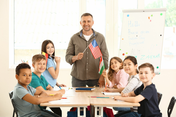 Παιδιά και δάσκαλος κατά τη διάρκεια του μαθήματος στο σχολείο ξένων γλωσσών - Φωτογραφία, εικόνα