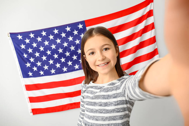 Allievo della scuola di lingua scattando selfie vicino al muro luminoso con bandiera USA - Foto, immagini