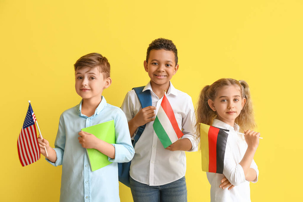 Pupils of language school with different flags on color background - Photo, image