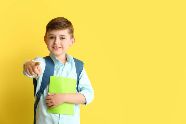 Niño de la escuela apuntando al espectador en el fondo de color - Foto, Imagen