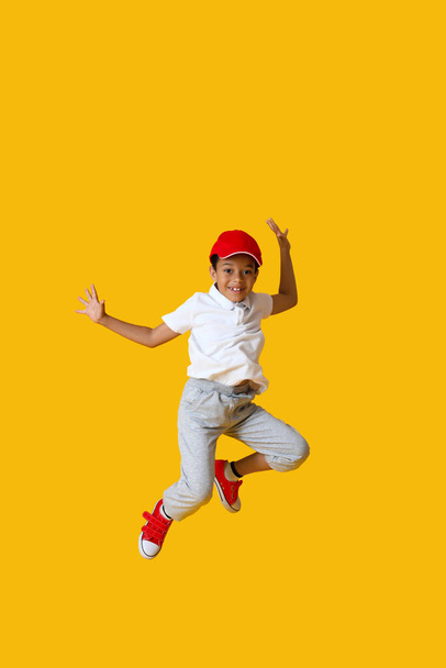 Tanzender afroamerikanischer Junge auf farbigem Hintergrund - Foto, Bild