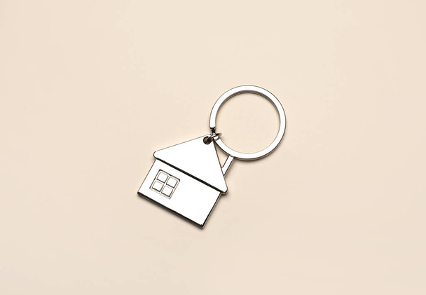 Silver house shaped keychain with keyring on beige background - Photo, Image
