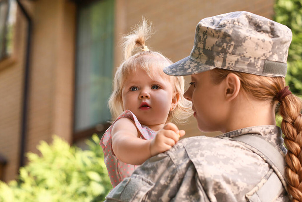Θλιβερό κοριτσάκι με τη στρατιωτική της μητέρα έξω - Φωτογραφία, εικόνα