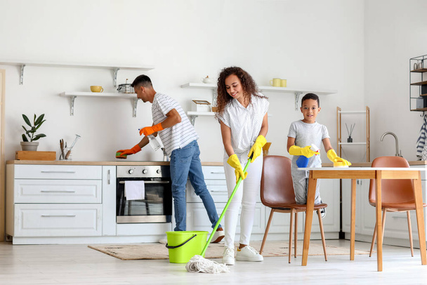 Happy interracial family cleaning kitchen - Фото, зображення