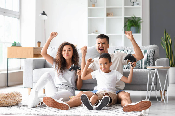 Happy interracial family playing video game at home - Foto, imagen