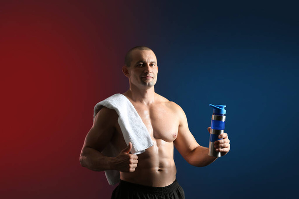 Male bodybuilder with protein shake on dark background - Foto, Imagen