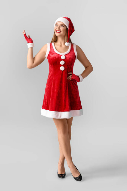 Kaunis nuori nainen Santa puku harmaalla taustalla - Valokuva, kuva