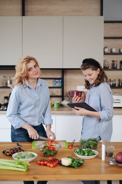 Mother and daughter teenager cooking together - Fotó, kép