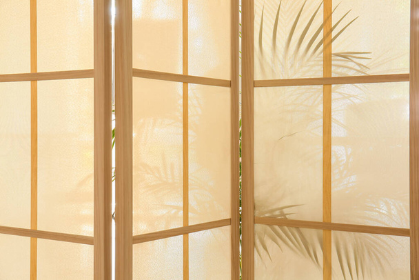 Pantalla plegable y silueta de hojas de palma como fondo - Foto, imagen