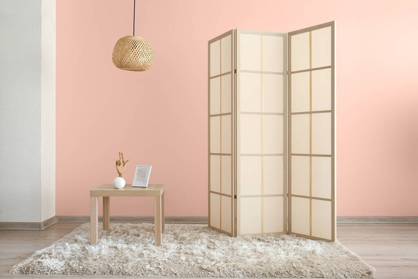 Stylová skládací stěna a malý stolek u zdi v pokoji - Fotografie, Obrázek