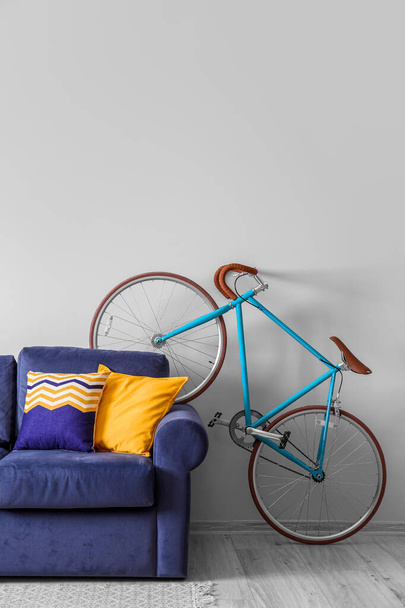 Stijlvol interieur met fiets en blauwe bank in de kamer - Foto, afbeelding