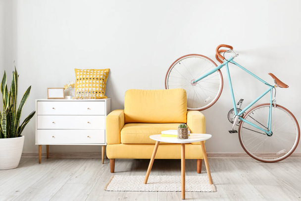 Κομψό εσωτερικό με ποδήλατο και κίτρινη πολυθρόνα στο δωμάτιο - Φωτογραφία, εικόνα
