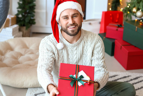 Красива людина з подарунком вдома напередодні Різдва
 - Фото, зображення