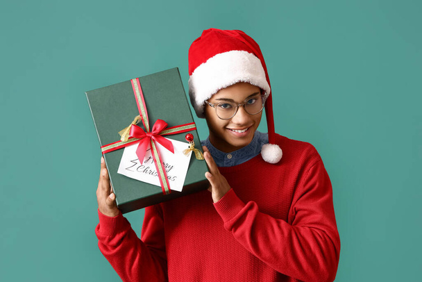 Afroamerykanin z prezentem świątecznym na tle koloru - Zdjęcie, obraz