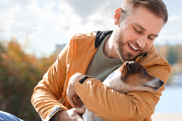 Handsome man with funny Jack Russel terrier on autumn day - Photo, Image