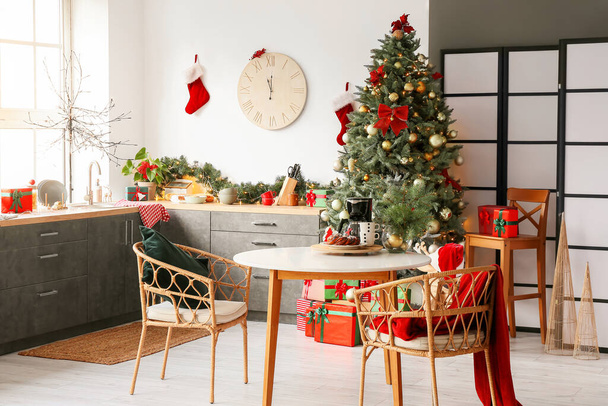 İçinde Noel ağacı ve yemek masası olan aydınlık modern mutfak. - Fotoğraf, Görsel