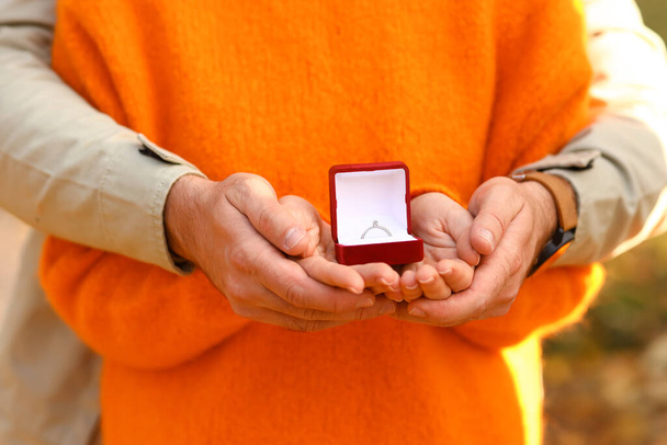 Young couple holding box with engagement ring, closeup - Fotoğraf, Görsel
