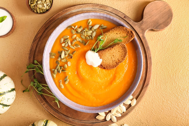 Bowl with delicious pumpkin cream soup on color background - Foto, Bild