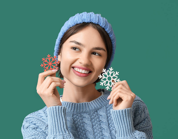 Beautiful young woman with snowflakes on color background - Photo, Image