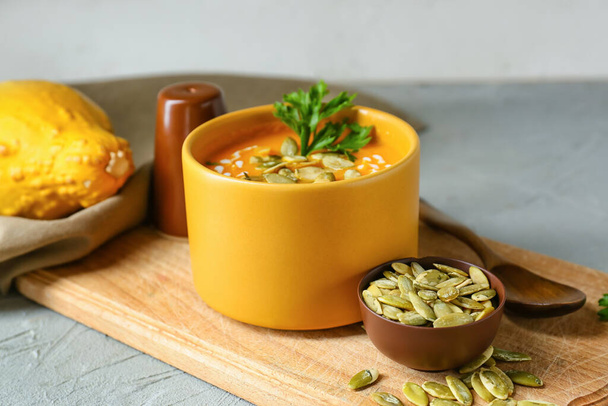Miska z pyszną zupą z dyni i nasionami na stole, zbliżenie - Zdjęcie, obraz