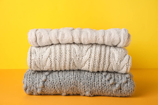 Stack of knitted sweaters on color background - Photo, Image
