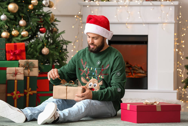glücklicher Mann mit Weihnachtsgeschenken zu Hause - Foto, Bild