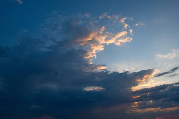 Rosja. Południowa Syberia Wschodnia. Mroczne zachmurzenie słońca w wieczornym letnim niebie nad pasmami górskimi wschodniej Sayan. - Zdjęcie, obraz