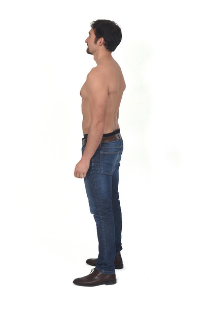 side view of a man shirtless and with blue jeans on white background - Фото, изображение