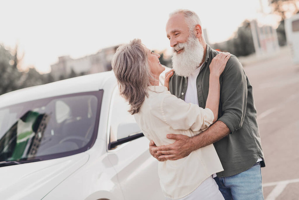 Profile side photo of senior lovely couple hug embrace romantic trip vacation automobile vehicle rent road outdoors - 写真・画像