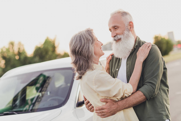 Photo of happy joyful old wife husband people man woman enjoy car rent hug harmony outdoors outside in urban city - Фото, зображення