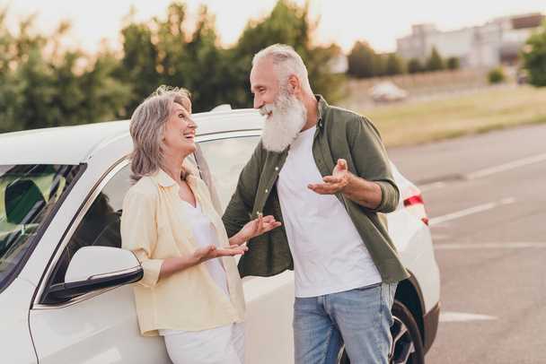 Photo of funny beautiful retired couple wear casual clothes driving car talking smiling outside urban city street - Foto, Imagem