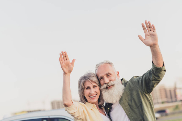 Photo of old people man woman wave hands hello good mood enjoy car park outdoors outside in urban city - Foto, immagini
