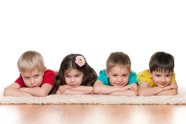 Children lie on the white carpet - Φωτογραφία, εικόνα